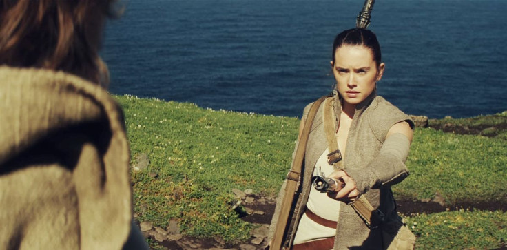 Rey (Daisy Ridley) handing a lightsaber to Luke Skywalker (Mark Hamill) in 'Star Wars: The Force Awakens'