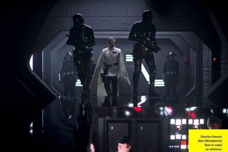 Ben Mendelsohn, as Director Krennic, stands before Deathtroopers.