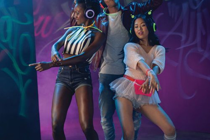 A group of diverse and stylish young people wearing the Brookstone wireless cat ear headphones. Maybe it's a silent rave??
