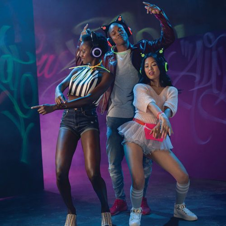 A group of diverse and stylish young people wearing the Brookstone wireless cat ear headphones. Maybe it's a silent rave??
