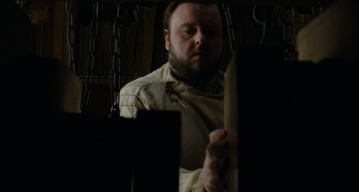 Sam reshelving alongside chained books.