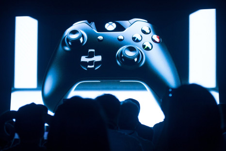 People look at a screen showing a controller during the presentation of the Xbox One in Shanghai on July 30, 2014.