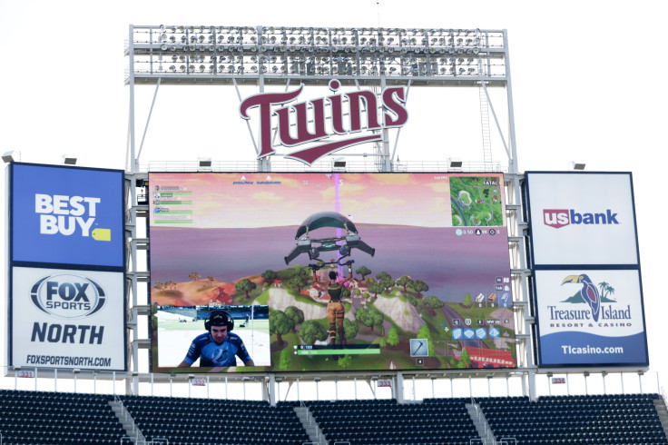 Minnesota Twins pitcher Trevor May plays the video game Fortnite with the live game projected on the stadium screen before the Minnesota Twins play the Kansas City Royals in their baseball game on September 9, 2018, at Target Field in Minneapolis, Minneso