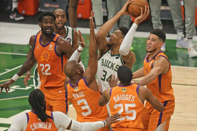 Giannis Antetokounmpo #34 of the Milwaukee Bucks tries to get off a shot under pressure from (L-R) Jae Crowder #99, Deandre Ayton #22, Chris Paul #3, Mikal Bridges #25 and Devin Booker #1 of the Phoenix Suns at Fiserv Forum on July 14, 2021 in Milwaukee, 