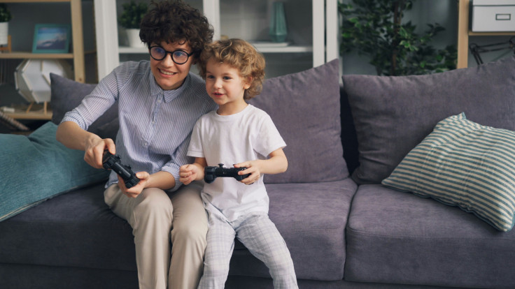 Mom and child playing video games on a couch